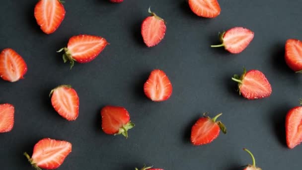 Fond rotatif noir avec des moitiés de fraise, vue de dessus — Video