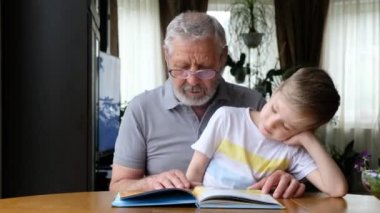 Büyükbaba kıdemli adam torunuyla kitap okuyor.