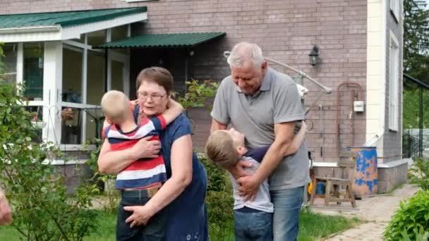 Gran reunión familiar - los niños mayores visitan a los abuelos mayores, tres generaciones se reúnen al aire libre — Vídeos de Stock