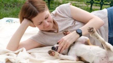 Yaz aylarında sevimli köpek köpeğiyle oynayan bir kadın.