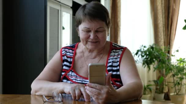 高级妇女手持智能手机，通过语音呼叫 — 图库视频影像