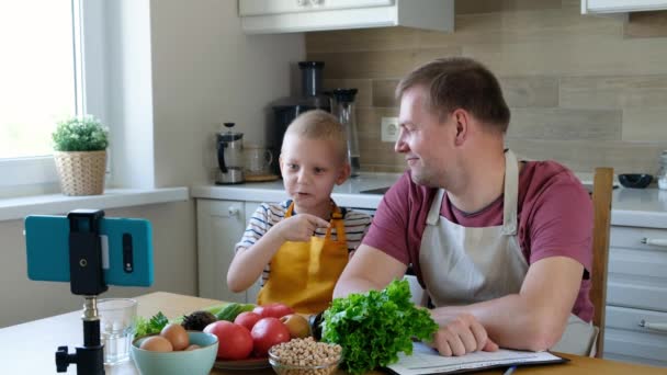 Bloger żywności facet i chłopiec mówi o zdrowej żywności do kamery, vlog żywności — Wideo stockowe