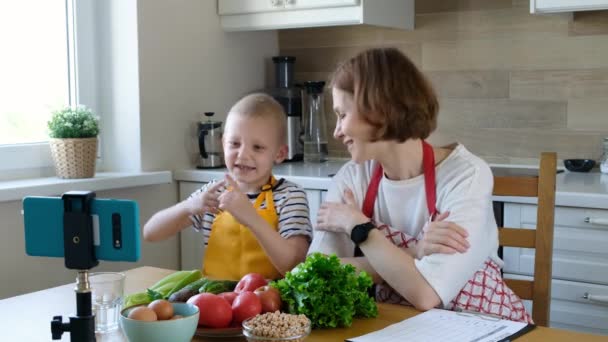 Food blogger γυναίκα και ένα παιδί αγόρι μιλάμε για υγιεινά τρόφιμα στην κάμερα, vlog τροφίμων — Αρχείο Βίντεο