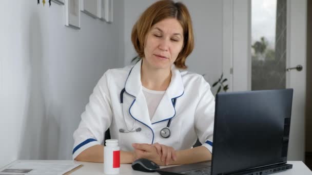 Kobieta lekarz nosić mundur ze stetoskopem rozmawiać przez telekonferencję, skonsultować się z pacjentem online patrząc na kamerę internetową, odległe konsultacje medyczne w koncepcji aplikacji internetowej — Wideo stockowe