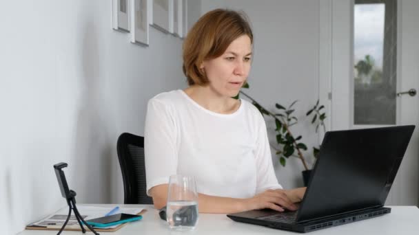 Frau arbeitet am Computer und bekommt schlechte Nachrichten, fühlt sich frustriert, gestresst und verärgert — Stockvideo