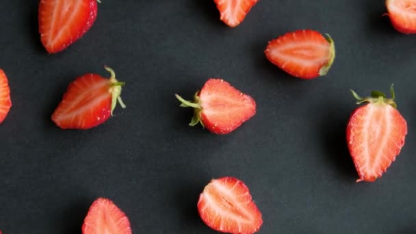 Fond rotatif noir avec des moitiés de fraise, vue de dessus — Video