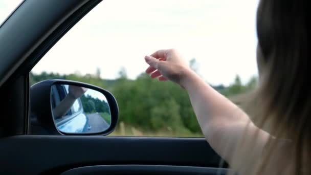Mulher livre viaja de carro pega o vento com a mão da janela do carro. Conceito de liberdade de verão — Vídeo de Stock