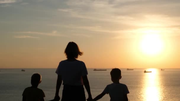 Familie kvinde med børn kigger på solnedgang ved havet – Stock-video