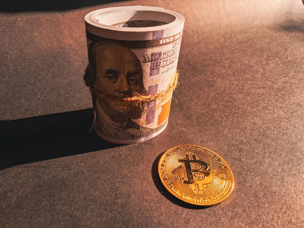 golden bitcoin with a hundred dollar bills and the virtual virtual currency.