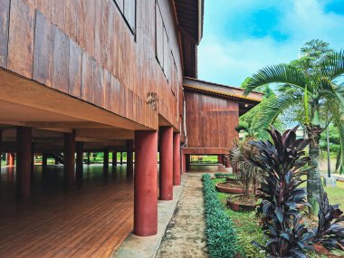 wooden house with a large window and a red roof in the background