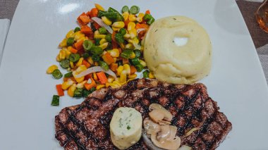 steak with vegetables, potatoes and mushrooms