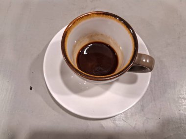 Siyah bir masada beyaz bir fincanda kahve.