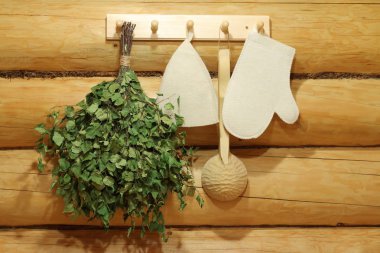 Geleneksel sauna aksesuarları duvarda asılı.
