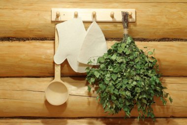 Geleneksel sauna aksesuarları duvarda asılı.