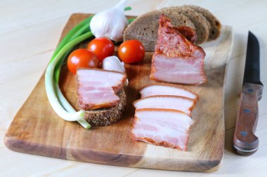 Pastırma ile ekmek ve sebze doğrama tahtası üzerinde bir parça.