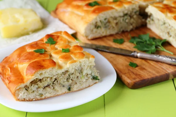 Taze pişmiş balık pasta üzerinde yeşil bir ahşap masa.