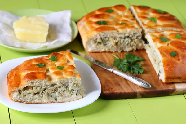 Freshly baked fish pie on a green wooden table.