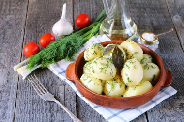 Sebze ile ahşap masada bir kil kase içinde Haşlanmış patates.