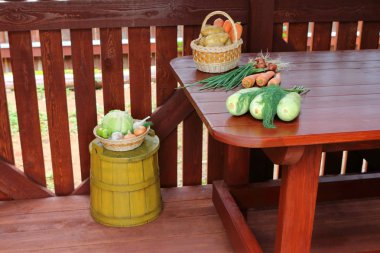 Ahşap bir barakada masada farklı taze sebzeler.