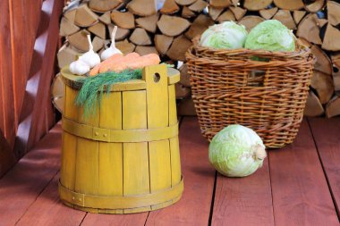 Tahta bir barakada sarı küvette taze sebzeler.