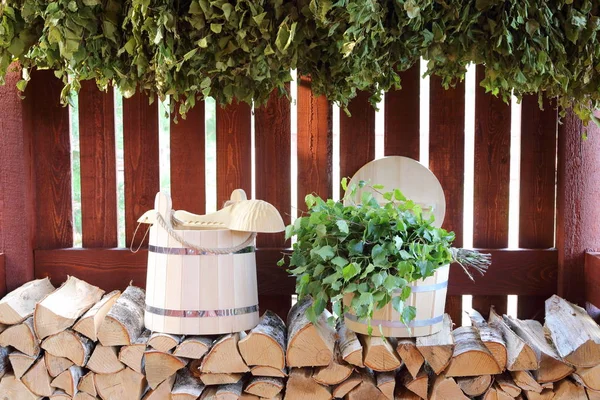 Sauna aksesuarları arasında ahşap bir kulübede Birch süpürgeler.