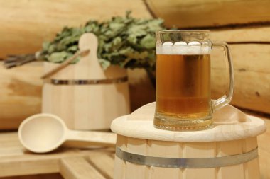 Saunada ahşap bankta soğuk ışık bira ve sauna aksesuarları Kupa. 