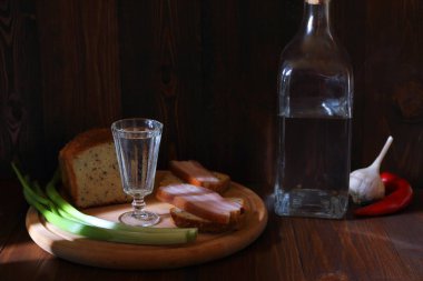  Domuz atıştırması ve taze sebzeler arasında bir bardak soğuk votka. Koyu gıda fotoğraf. 