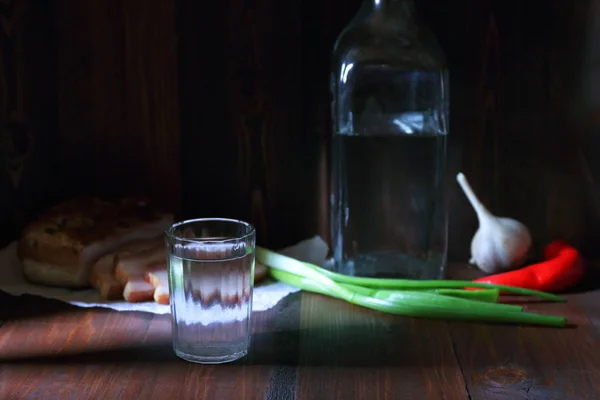 Ein Glas Kühlen Wodka Zwischen Schweinesnack Und Frischem Gemüse Dark — Stockfoto