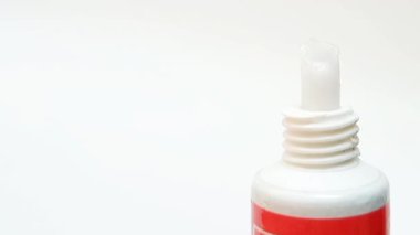 Beyaz arka plan, tıbbi, kozmetik veya cilt ürünleri içeren bir tüpten beyaz krem çıkıyor.