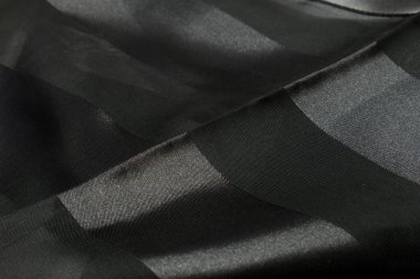 Bu siyah polyester eşarbın dantelli bir fotoğrafı.