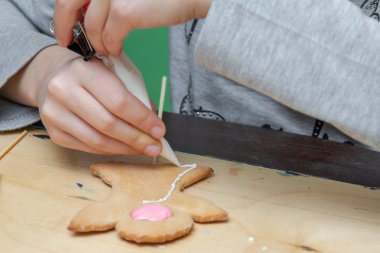 Çocuk ana sınıfı ile renkli sır zencefil kek dekorasyon. Kız zencefil kurabiye boyar. Noel davranır. El yapımı kurabiye.