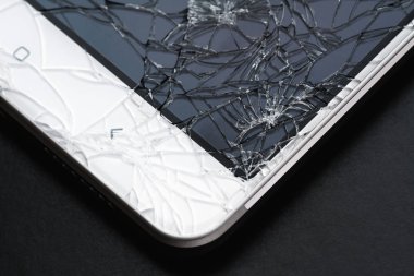 Kırık ekran. Akıllı telefon camı hasar görmüş. Yakın plan, koyu arkaplan, seçici odak