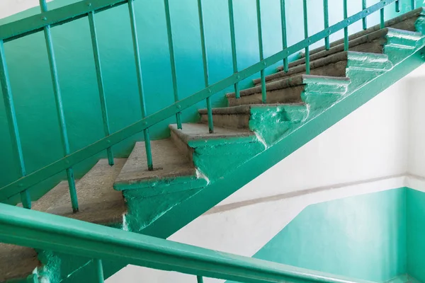 Eski beş katlı binanın tırabzanıyla beton merdiven.