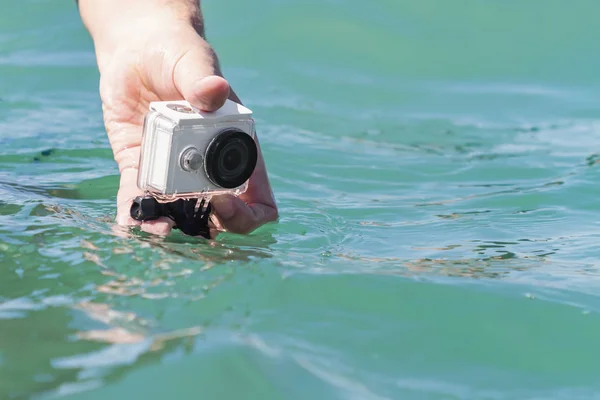 水中のアクションカメラで男が水中で写真とビデオを撮っています。閉鎖的選択的焦点 — ストック写真