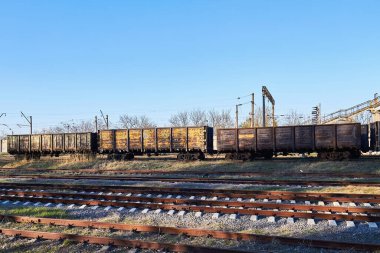 Güneşli bir günde raylarda eski, paslı tren vagonları. Sanayi krizi