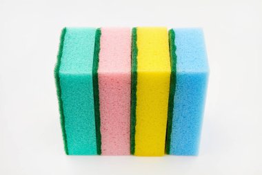 Bulaşık yıkamak, banyoyu temizlemek ve diğer ev ihtiyaçlarını karşılamak için beyaz arka planda çok renkli sünger seti. Yakın çekim.