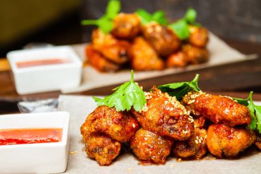 Soslu ve maydanozlu susamlı tavuk kanadı. Yakın çekim, seçici odaklanma