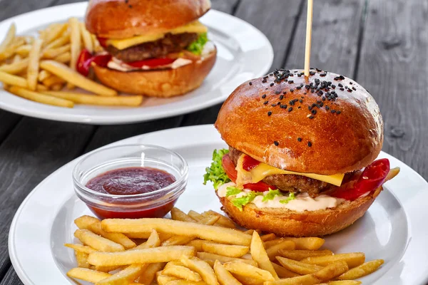 Dwa Hamburgery Kotletem Wołowym Serem Frytkami Pomidorem Sałatką Sosem Ketchupem — Zdjęcie stockowe