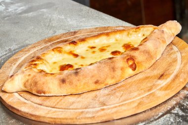 Geleneksel yassı ekmek khachapuri ya da ahşap bir tahtanın üzerinde peynir ve yumurta ile hachapuri. Yemek pişirme süreci