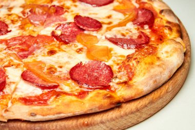 Salamlı, dolmalık biberli, domatesli ve peynirli bir pizza. Yakın çekim, seçici odaklanma