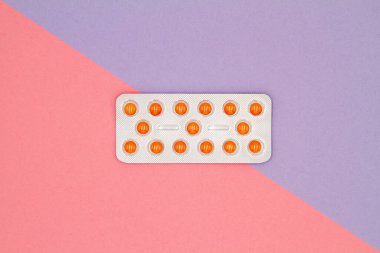 Renkli arka planda su toplamış turuncu hapların üst görüntüsü. Sağlık hizmetleri kavramı