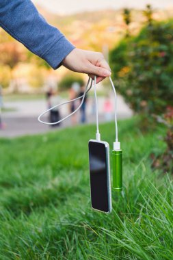 Kız kabloyla tutuyor akıllı telefonu ve harici bir güç bankasını şarj ederken