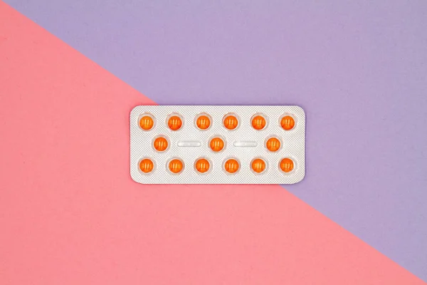 Renkli arka planda su toplamış turuncu hapların üst görüntüsü. Sağlık hizmetleri kavramı