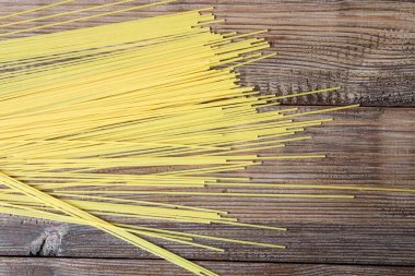 Kahverengi ahşap arka planda makarna ya da spagetti. Üst görünüm