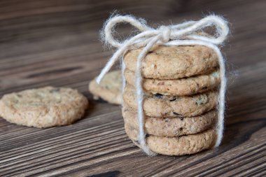 Koyu ahşap arka planda çikolata parçacıklı kurabiye yığını.