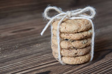 Koyu ahşap arka planda çikolata parçacıklı kurabiye yığını.