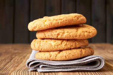 Kahverengi peçeteye ve tahta masaya istiflenmiş kurabiyeler.