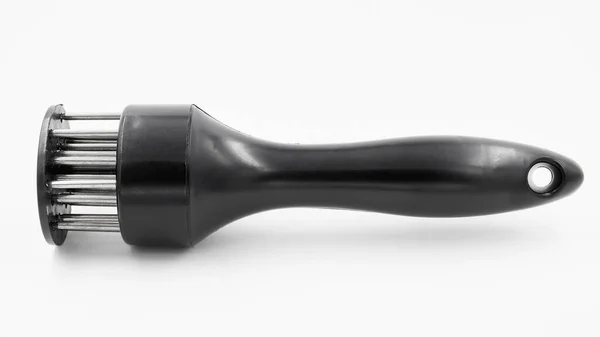 Eti delmek ve beyaz arka planda kasların liflerini kesmek için elle güçlendirilmiş et yumuşatıcısı.