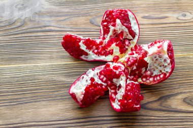 Kahverengi ahşap zemin üzerinde taze olgun nar açın. Olgun bir taş. Seçici odak