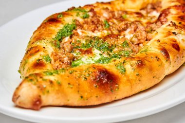 Beyaz tabakta Khachapuri eti. Yakın çekim, seçici odaklanma